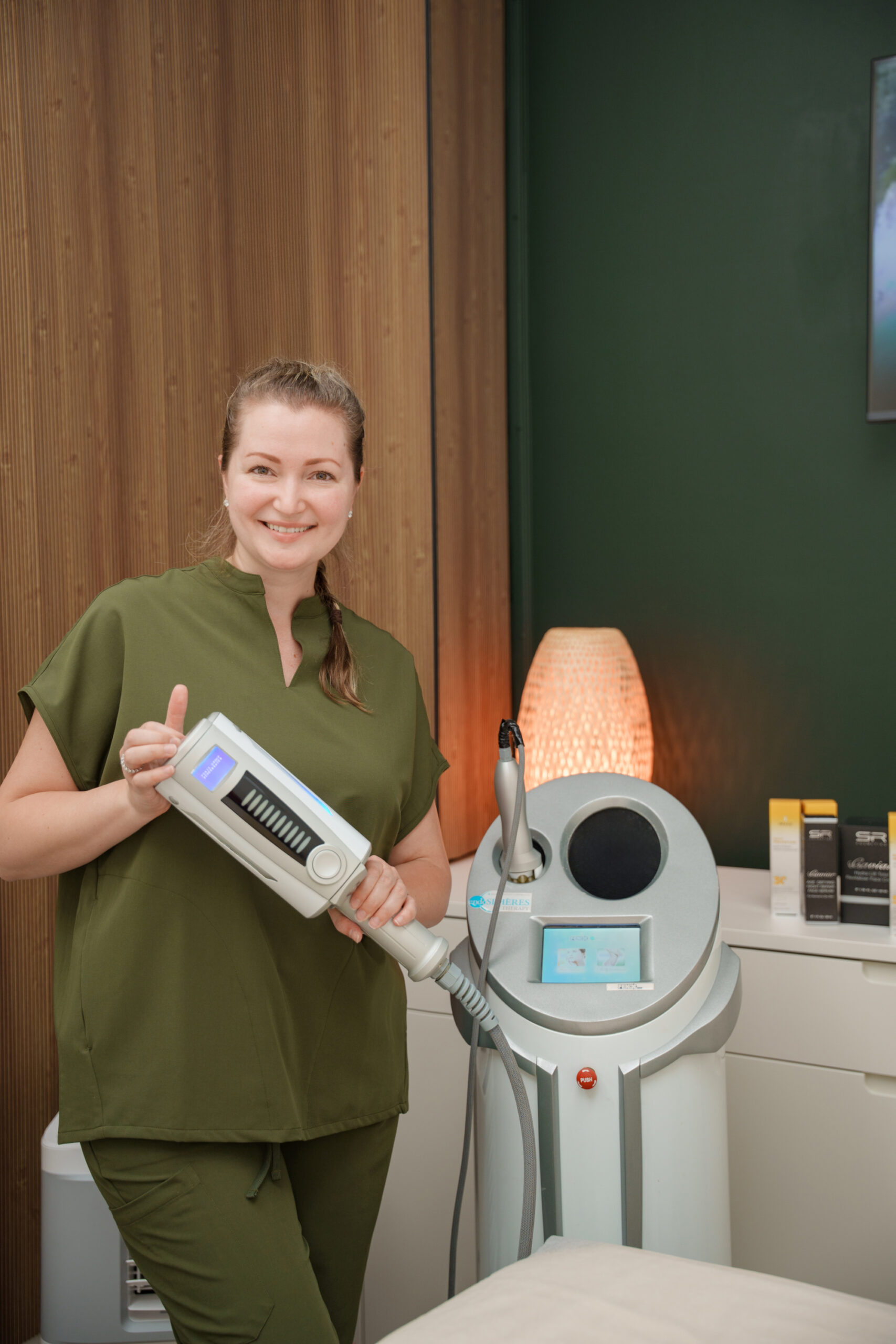 Daria Havlovskyy in olive scrubs holding an Endosphères Therapy handpiece at Glow Lab